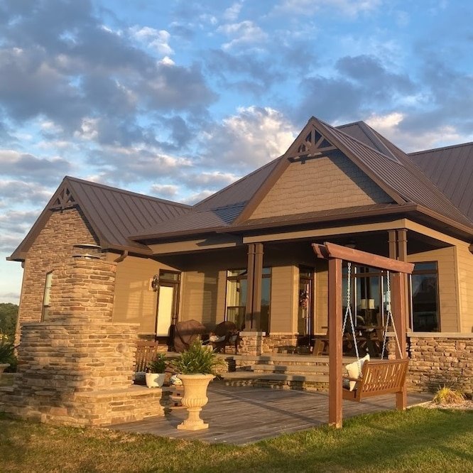 A new shingle roof installation on a picturesque home with a cloudy blue day in the background.