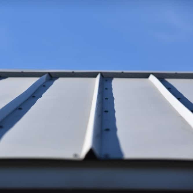 Snap lock metal roof seen with a clear blue sky in the background.